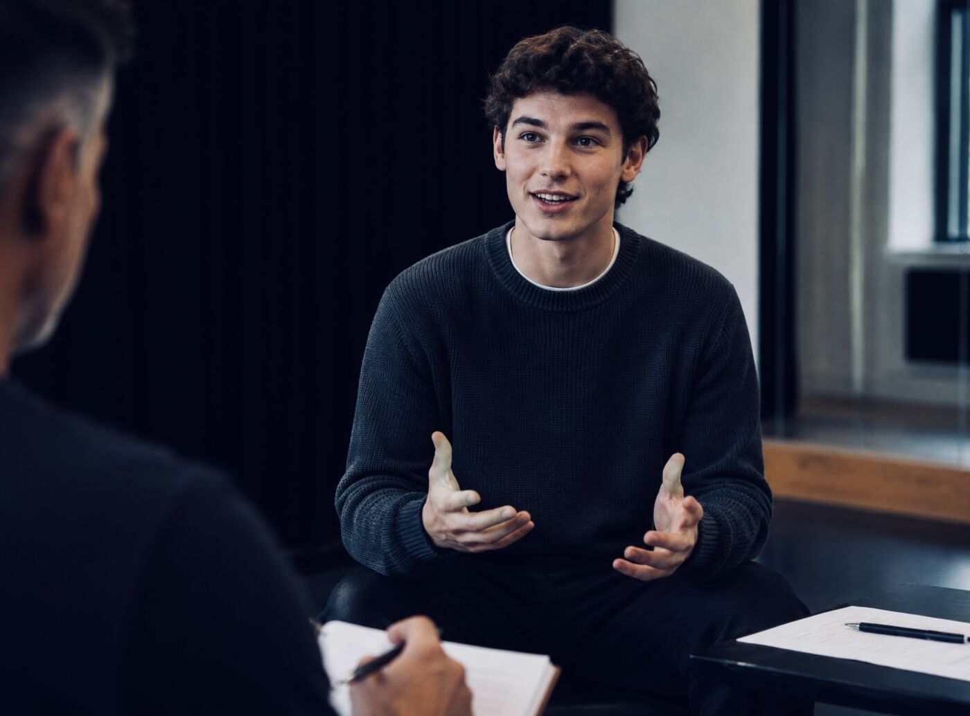 A young man answering questions confidently in an interview