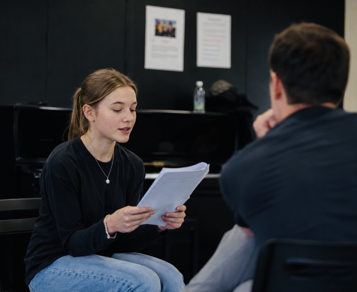 A student reading a scene aloud one-to-one with her coach